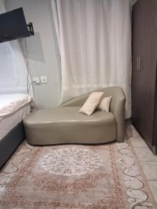 een groene bank in een hoek van een kamer bij TripleM comfort zone in Windhoek