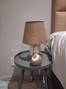 een lamp op een tafel naast een bed bij TripleM comfort zone in Windhoek