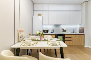 a kitchen with a white table and chairs at Oasis Халал апартаменты возле самой большой Мечети Центральной Азии in Astana