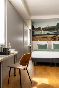 パリにあるMidnight Hôtel Parisのベッドと椅子と机のある寝室