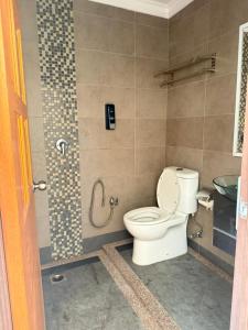 un baño con inodoro y lavabo en Tomato Motel, en Pantai Cenang