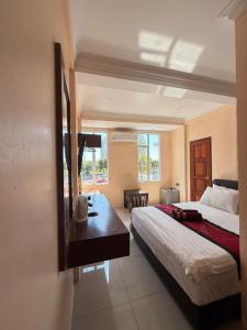 Un dormitorio con una cama y un escritorio. en Tomato Motel, en Pantai Cenang