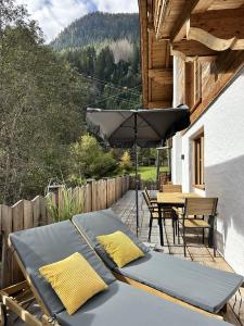 a patio with an umbrella and a table and chairs at Chalet am Bachl 1 in Flattach
