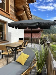 a patio with a table and an umbrella at Chalet am Bachl 1 in Flattach