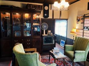 a living room with two chairs and a tv at はやちねの宿ラビット in Hanamaki