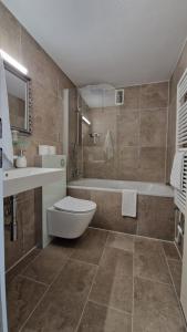 a bathroom with a toilet and a sink and a tub at Apart Hotel Freiburg in Freiburg im Breisgau