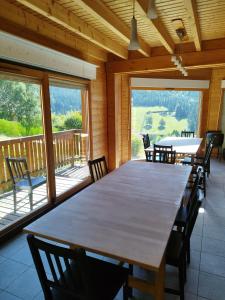 ein großes Esszimmer mit einem großen Tisch und Stühlen in der Unterkunft Grand Valtin : chalet écolo 4 étoiles 14 personnes in Ban-sur-Meurthe-Clefcy