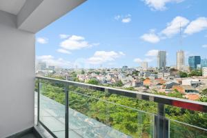 a balcony with a view of a city at Magnolia ApartHotel by Kozystay - Kebon Jeruk in Jakarta