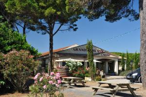 - une table de pique-nique devant un bâtiment fleuri dans l'établissement Happy Camp Mobile Homes in Camping Le Domaine La Yole, à Vendres