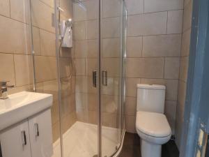 a bathroom with a shower with a toilet and a sink at Heath Hideaway in Sowerby Bridge