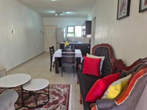 a living room with a couch and a table and chairs at Elegant Bliss -2 bedroomed at Dainfern, in Fourways, Sandton in Fourways