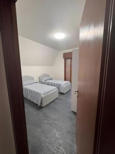 two beds sitting in a room with a hallway at Casa Aris in Staranzano