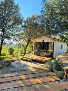 a small house with a porch and a deck at Suite privée indépendante en bois- Sud Ardèche in Saint-Paul-le-Jeune