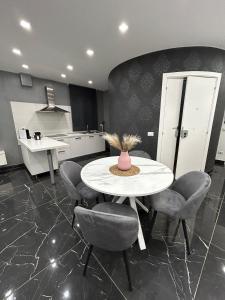 una cucina con tavolo e sedie bianchi e bancone di Il piacere-Luxury apartments a Caltagirone