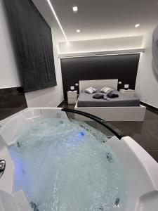 una vasca da bagno in una camera con un letto di Il piacere-Luxury apartments a Caltagirone