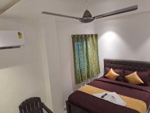 a bedroom with a bed and a ceiling fan at Hotel O Sri Sakthi Mahal in Chennai +2 photos