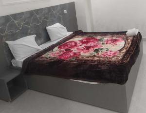 a bed with a wooden headboard with flowers on it at Hotel O Celebration in Indraprast