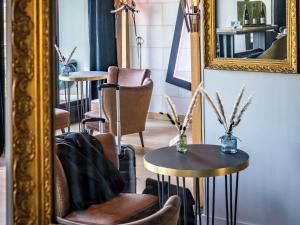 a mirror and two tables and chairs in a room at Mercure Bords de Loire Saumur in Saumur +250 photos