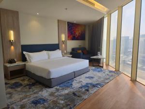 a bedroom with a large white bed and a large window at Best Western Premier in Riyadh