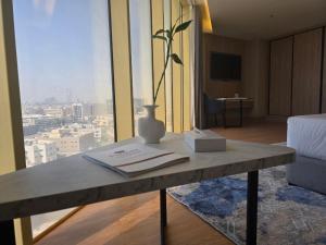 a table with a vase on it in a room with a window at Best Western Premier in Riyadh