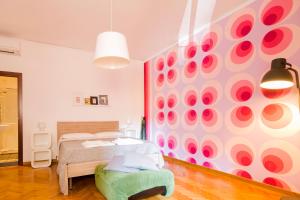 ナポリにあるI Quattro Gattoniのベッドルーム1室(ベッド1台付)、壁に水玉が付いています。