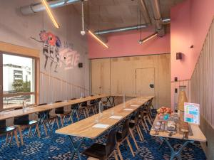 a row of tables in a room with pink walls at Eklo Bordeaux Centre Bastide in Bordeaux