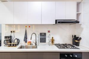 a kitchen with white cabinets and a sink at Westlands Oasis, Luxury Pool, Gym & Gaming Fun in Nairobi +45 photos