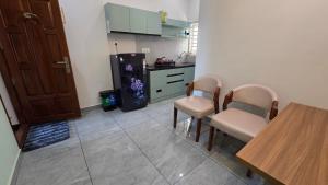 a kitchen with a table and chairs and a refrigerator at Olive Inn Apartment in Alwaye