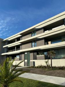 Un gran edificio con palmeras delante. en VAGUEIRA Sol, en Vagos
