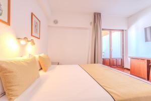 a bedroom with a large white bed with a window at Hotel ITC Ciudad de Haro in Haro