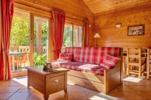 ein Wohnzimmer mit einer roten Couch in einer Hütte in der Unterkunft Rossa - ski, vue Montagne, Spa & Terrasse in Champagny-en-Vanoise