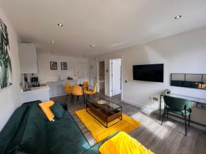 uma sala de estar com um sofá verde e uma cozinha em Kings Lodge By Nivaas 1 em Reading