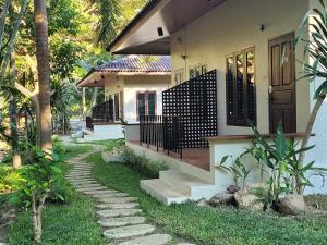 a house with a walkway in front of it at Cozy Cottage by Chanita in Suan Phung