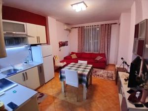 a kitchen and a living room with a red couch at Summer apartment by seaside for rent in Golem +9 photos
