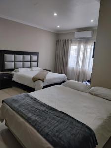 a hotel room with two beds and a window at 33onBazley Hotel in Durban