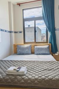 a bedroom with a bed with a large window at Phương Anh 2 - Hotel Bình Tân in Ho Chi Minh City