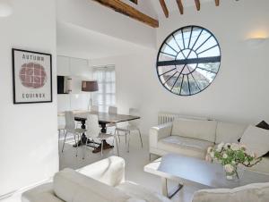 a living room with white furniture and a table at Courtyard Cottage, Pulborough in Pulborough