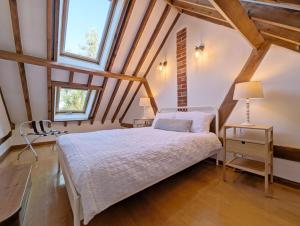 a bedroom with a bed and two windows at Courtyard Cottage, Pulborough in Pulborough