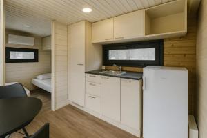 a small kitchen with a refrigerator and a table at Arctic Shaman Adventures -Jurtta in Köngäs