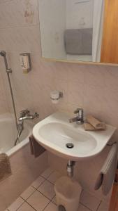 a bathroom with a sink and a tub and a toilet at Centre Thermal - Studio SUD terrasse in Ovronnaz