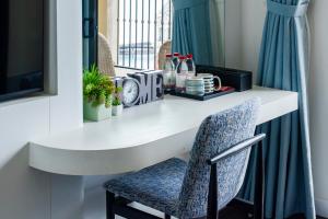 a white desk with a chair and a window at Lotus Grand Apartment - Firework View, Sunset Town Phu Quoc in Phu Quoc