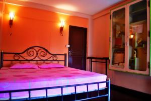 um quarto com uma cama com lençóis cor-de-rosa e uma janela em Pailin Guest House em Bangkok