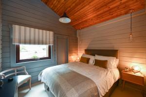 a bedroom with a bed in a wooden wall at Lyall Lodge in East Barcloy +11 photos