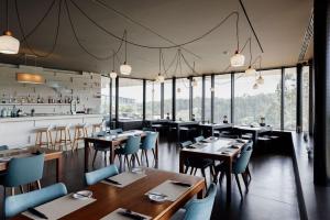un ristorante con tavoli e sedie in legno e finestre di Bom Sucesso Resort a Vau