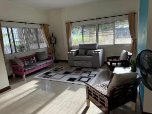 a living room with a couch and chairs and windows at Aonang Private Pink House 8 in Ao Nang Beach