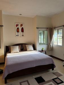 - une chambre avec un grand lit et 2 oiseaux sur le mur dans l'établissement Aonang Private House, à Ao Nang Beach