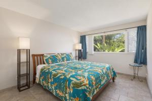 a bedroom with a bed and a window at Kona Coffee Villas E246 condo in Honalo