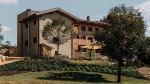 an old building with a tree in front of it at La Ghiandaia Farmhouse in Conegliano