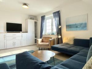 un soggiorno con un divano e una TV di Blankwasser 11 a Grömnitzerhagen