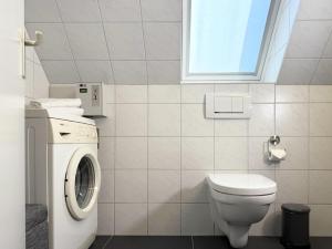 un bagno con WC e lavatrice di Blankwasser 11 a Grömnitzerhagen Altre 23 foto
